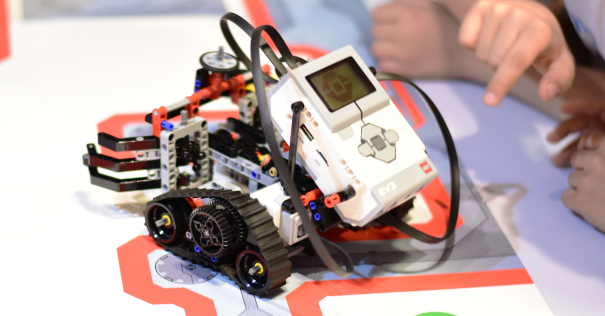 Child pointing at small robot on a table