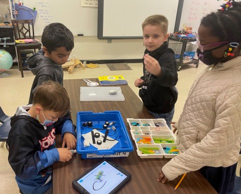 Boston Elementary School students working on classroom robotics around a table