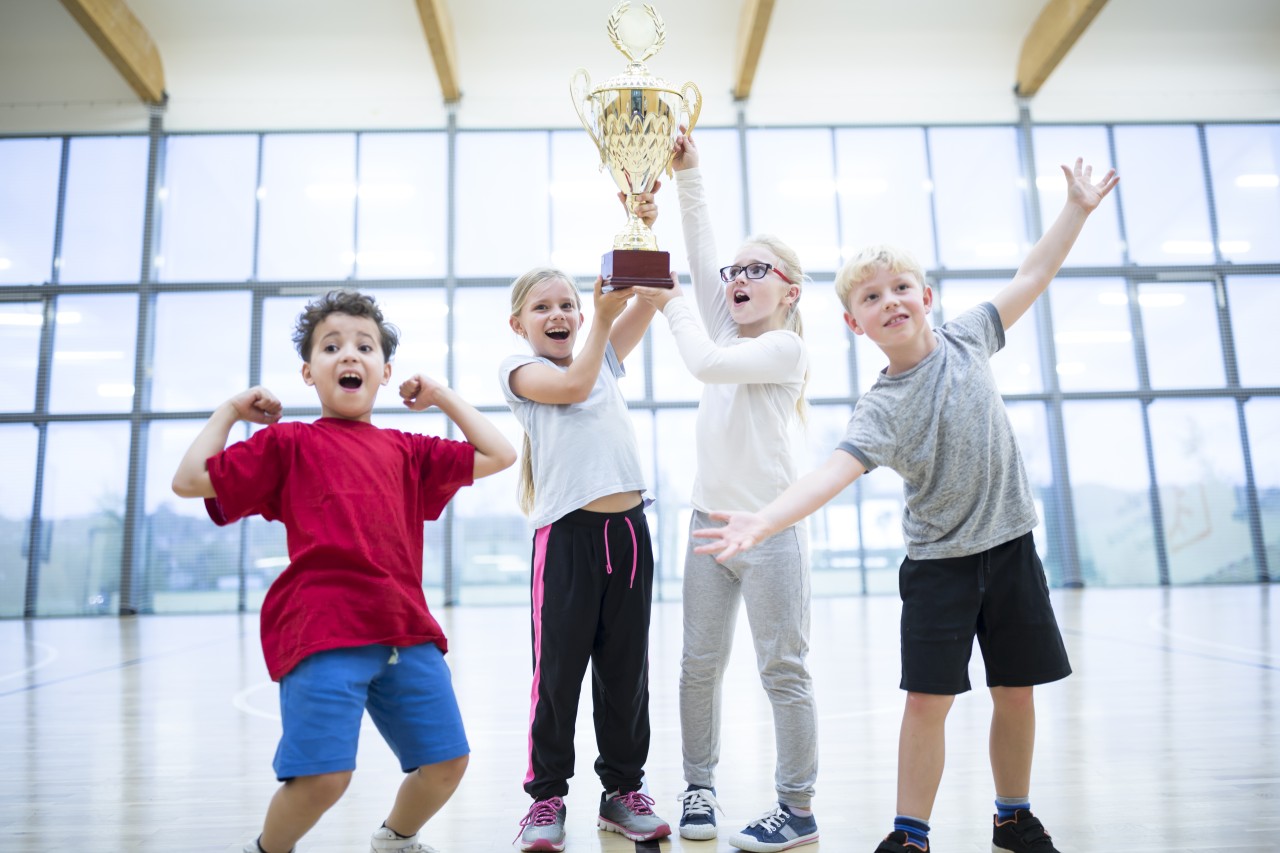 Kids holding trophy at school